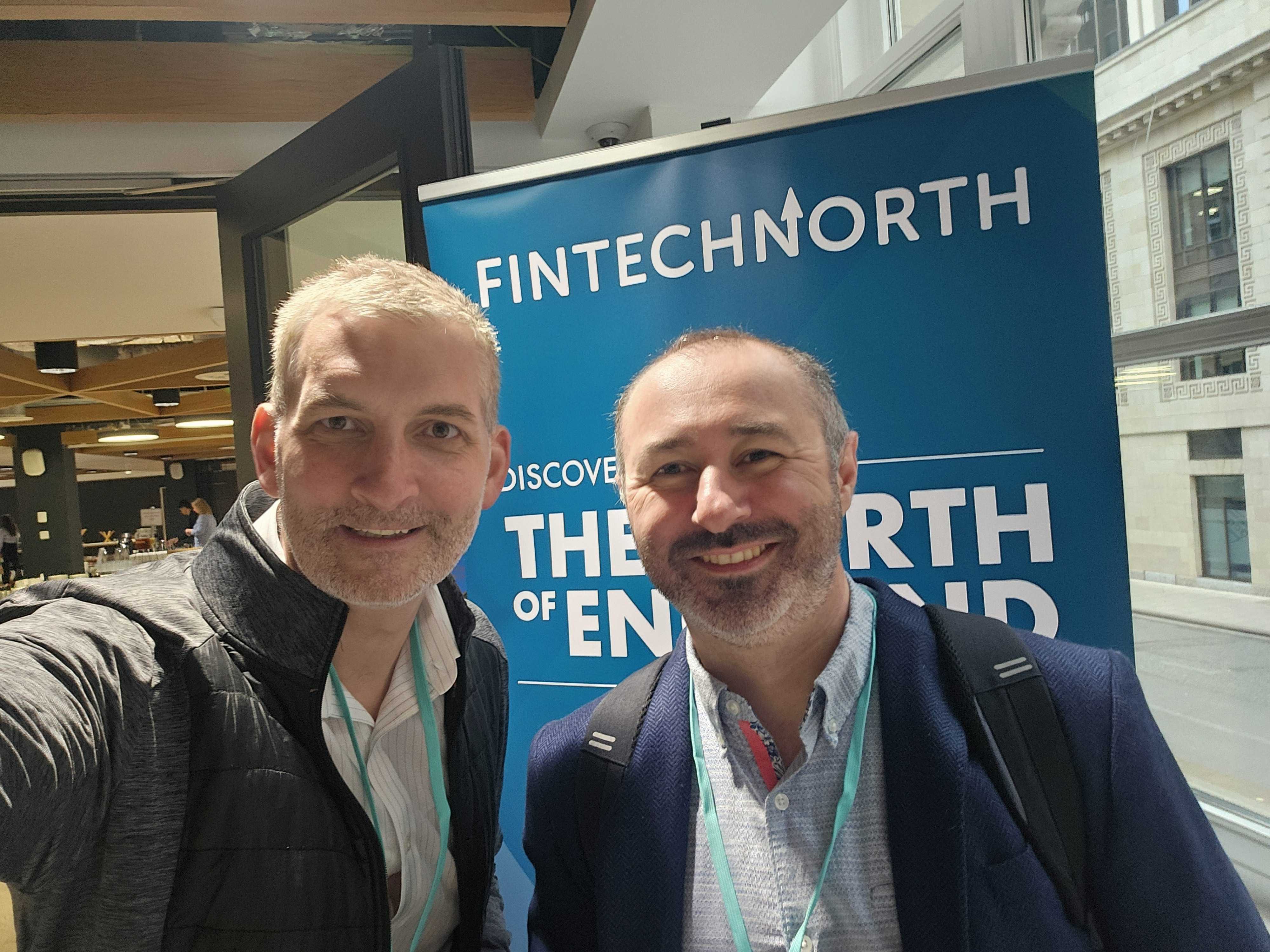 Two smiling men take a selfie in front of a