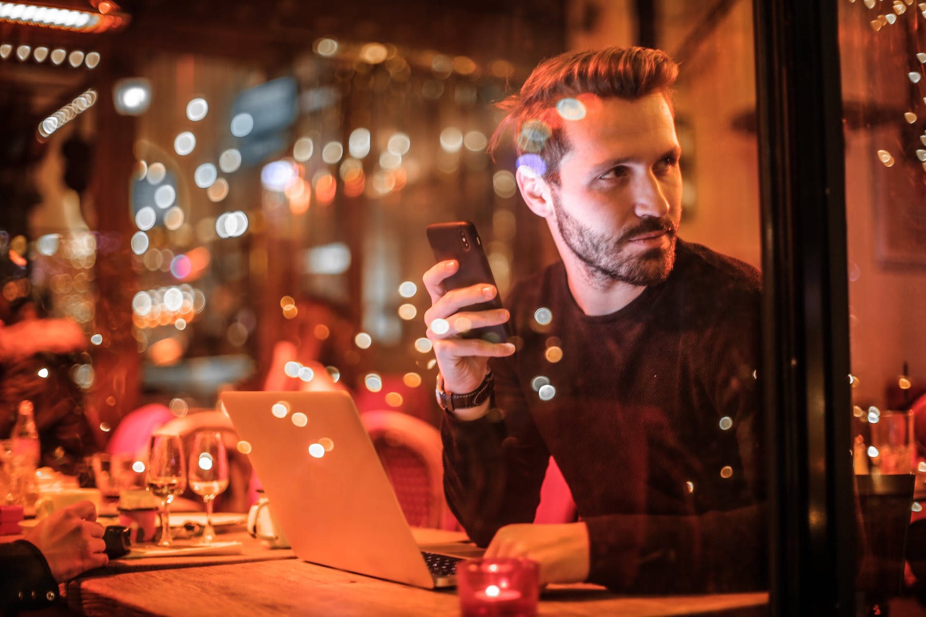 man sitting on phone and laptop